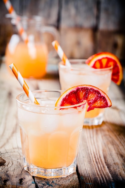Cocktail orange sanguine sans alcool dans un verre sur un fond en bois