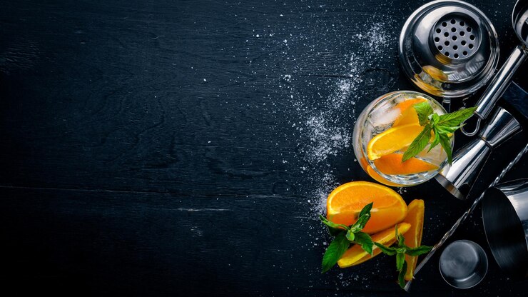 Photo cocktail d'oranges et de menthol avec de la glace, sur une surface en bois noire. vue de dessus. espace libre.