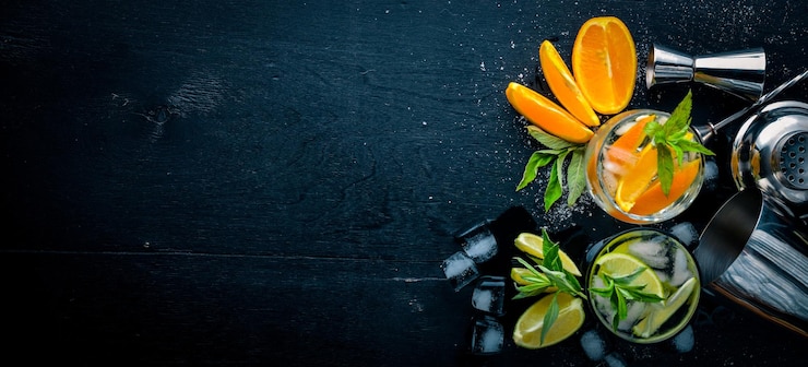 Photo cocktail d'oranges et de menthol avec de la glace sur une surface en bois noire vue de dessus espace libre