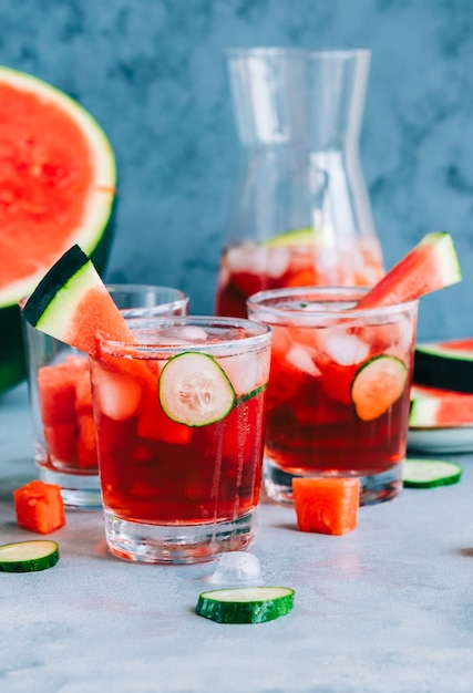 Cocktail de pastèque dans un verre avec tranche de concombre et glaçons sur la table. Boisson rafraîchissante