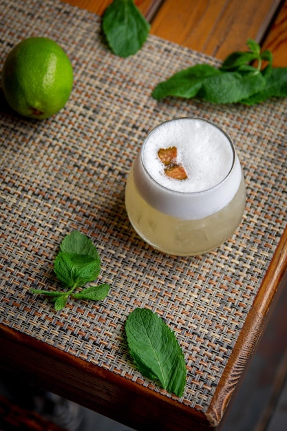 Cocktail péruvien alcoolisé Pisco Sour cocktail avec des ingrédients au citron sur fond de bois