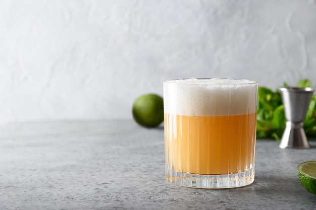 Cocktail de pisco sour. whisky au jus de citron vert, sirop de sucre et blanc d'oeuf en verre.