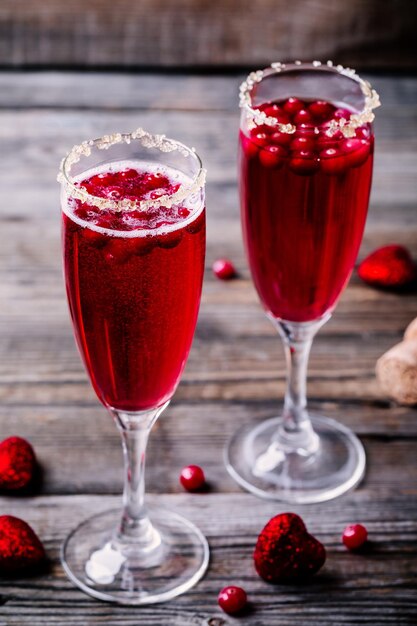 Cocktail rafraîchissant avec champagne et canneberge pour la Saint-Valentin sur fond de bois