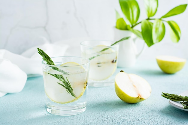 Cocktail rafraîchissant d'eau minérale et de tranches de poire dans des verres sur la table Boissons maison