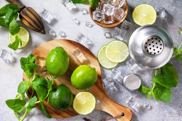 Cocktail rafraîchissant de mojito d'été froid faisant des ingrédients de glace à la menthe et au citron vert et des ustensiles de bar