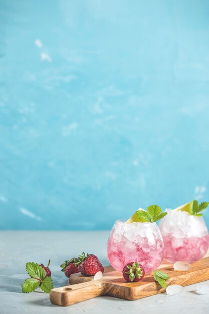 Cocktail rose avec fraises à glace pilée au citron vert et menthe sur fond clair mise au point sélective image copie épice pour votre texte vacances d'été et concept de fête