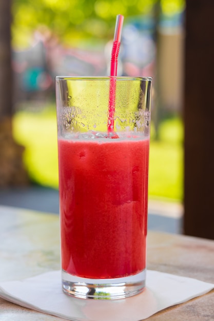 Cocktail rouge dans un verre avec une paille