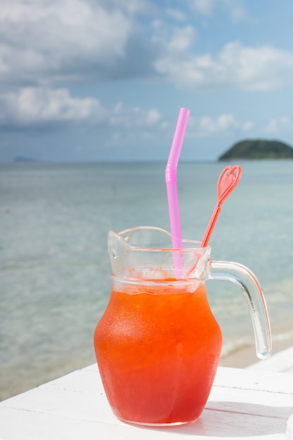 Cocktail rouge sur table blanche sur l'océan