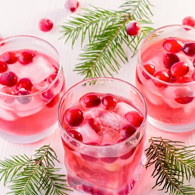 Cocktail sans alcool d'hiver avec canneberge et glace sur fond de bois, gros plan, vue de dessus