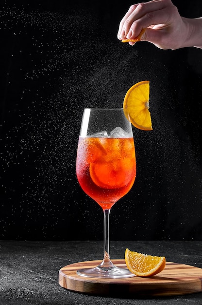 Cocktail Spritz en verre de vin sur planche de bois sur fond sombre