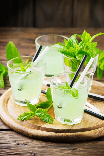 Cocktail sucré vert à la menthe et à la glace sur la table en bois