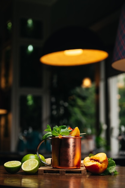 Cocktail en tasse de fer avec menthe pêche citron vert et gingembre