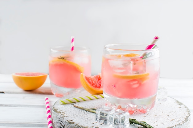 Cocktail avec une tranche de pamplemousse sur une table en bois