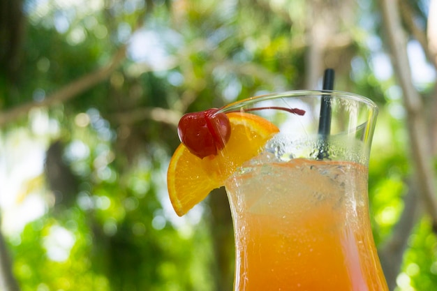 Cocktail tropical avec garniture d'orange et de cerise