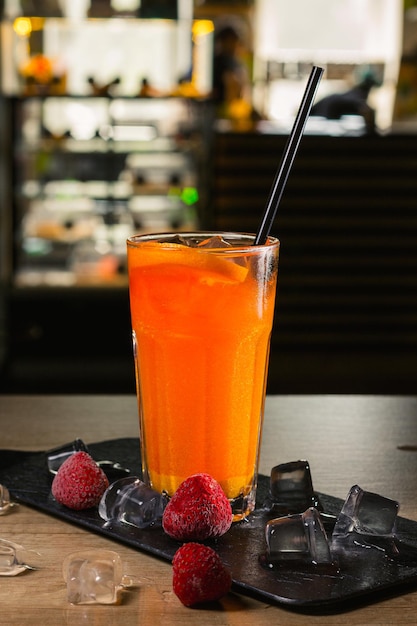 Cocktail tropical orange rafraîchissant aux agrumes et à la paille