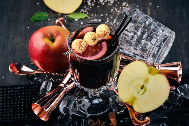 Un cocktail de vin rouge chaud Vin sur un fond en bois noir