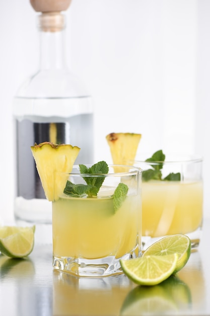 Cocktail de vodka au jus d'ananas, une tranche de citron vert, refroidi avec de la glace et de la menthe