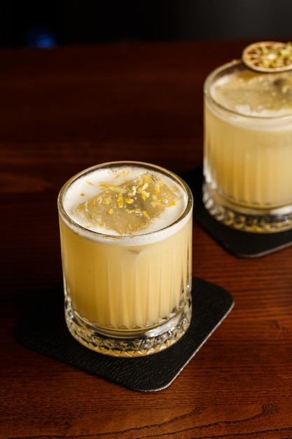 Des cocktails aux couleurs chaudes cocktail mezcal et alcoolique scotch whisky pénicilline boisson cocktail verre à cocktail sur le comptoir du bar