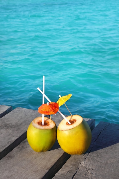 Photo cocktails de noix de coco dans les caraïbes sur le quai en bois