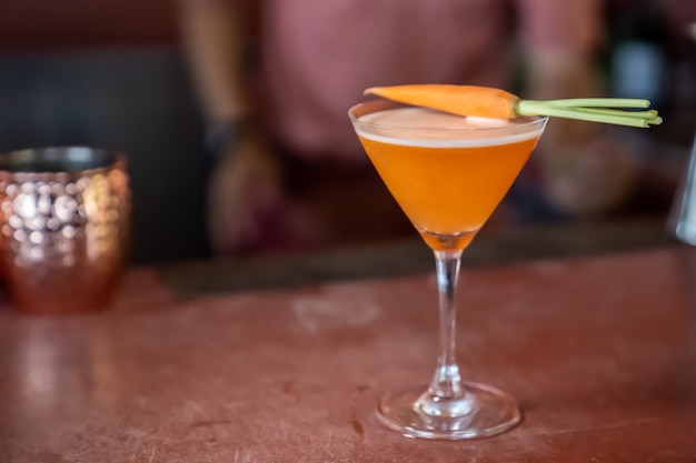 Les cocktails sans alcool aux carottes sont mélangés et prêts à servir sur une barre rouge.