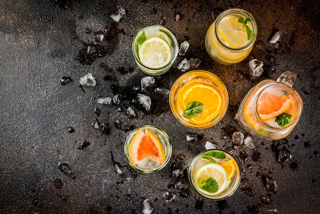 Cocktails santé en été, ensemble de différentes eaux infusées aux agrumes, limonades ou mojitos, pamplemousse citron citron orange, boissons désintoxicantes diététiques