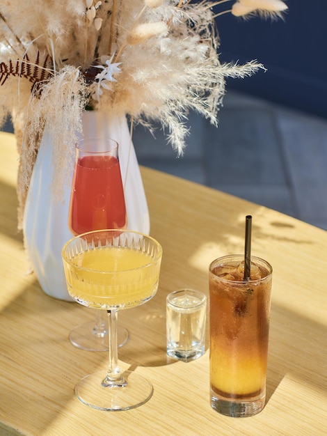 Cocktails sur la table Différentes boissons colorées dans différents verres sur une table en bois sombre sur fond de restaurant flou Bar concept boissons alcoolisées