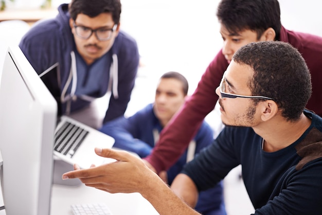 Codage collaboratif Photo d'un groupe de collègues travaillant avec un ordinateur dans un bureau