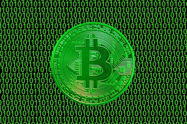 Code binaire vert et un précieux bitcoin vert de la vue directe de la monnaie crypto