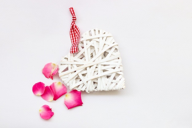 Coeur blanc décoratif fait de vignes Saint Valentin sur le fond d'un bouquet de roses