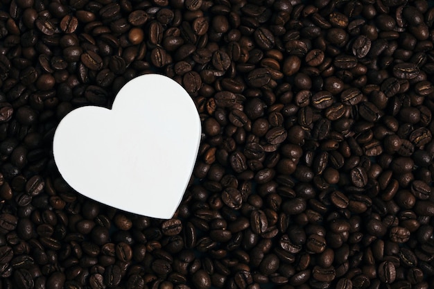 Coeur blanc sur fond de grains de café torréfiés