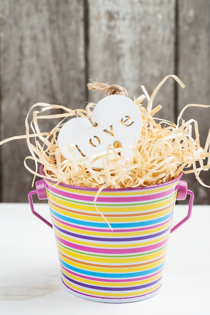 Coeur en bois blanc dans un seau dénudé