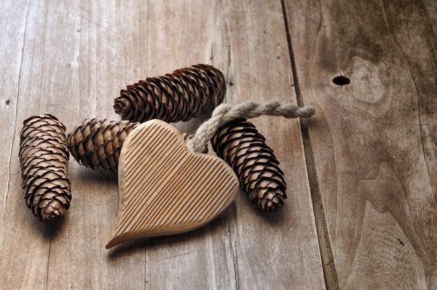 Coeur en bois et cônes de pins sur une table