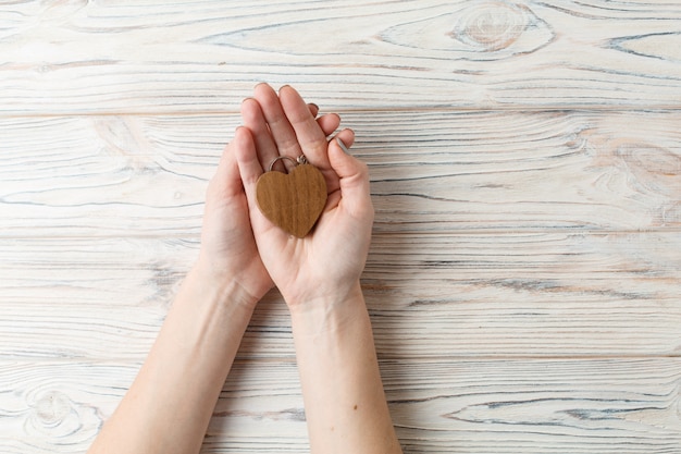 coeur en bois dans la paume des femmes se bouchent.