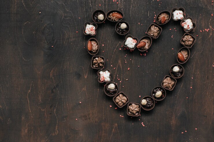 Coeur avec des bonbons au chocolat sur table en bois