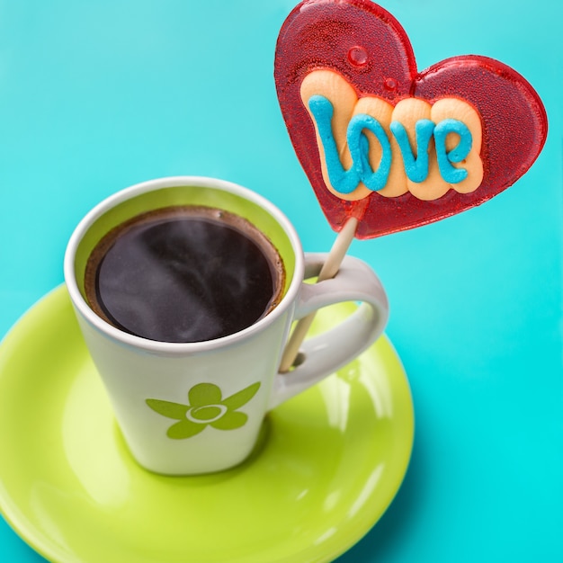 Coeur de bonbons sur un bâton et une tasse de café.