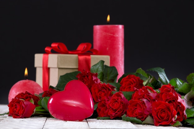 Coeur et un bouquet de roses rouges avec cadeau et bougies