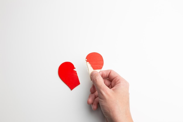 Un coeur brisé dans les paumes sur un fond blanc