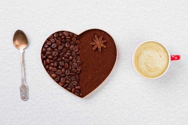 Coeur de café décoratif avec cuillère à café et tasse à café avec mousse. Isolé sur une surface blanche