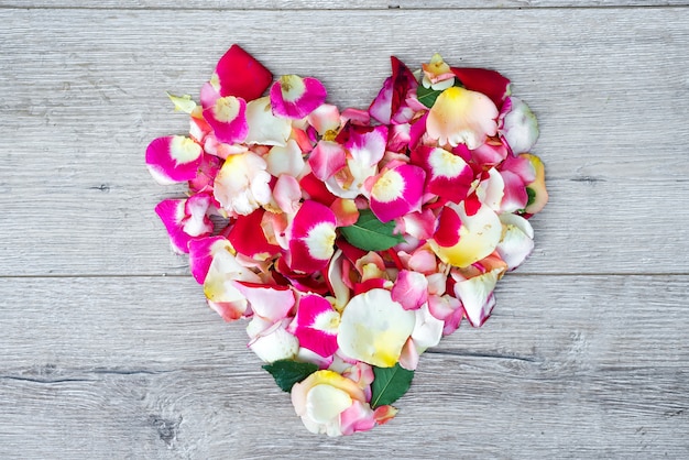 Cœur composé de fleurs roses sur fond en bois pour la Saint Valentin.