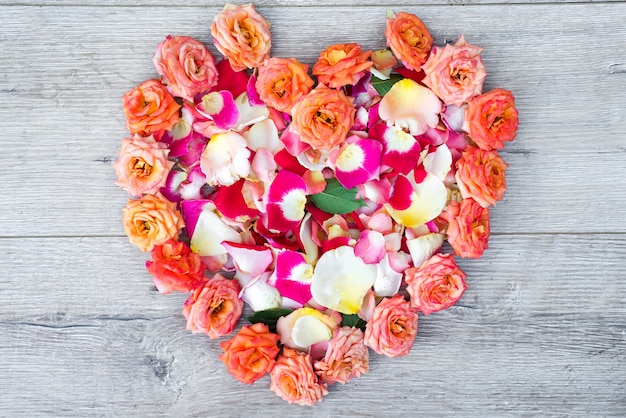 Cœur composé de fleurs roses sur fond en bois pour la Saint Valentin.