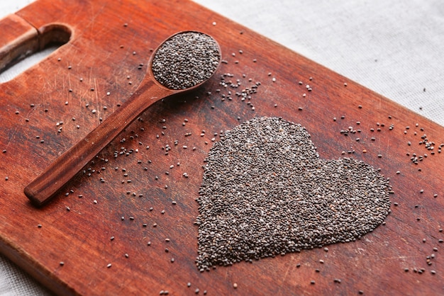 Coeur composé de graines de chia sur une table en bois. concept de santé et de saine alimentation