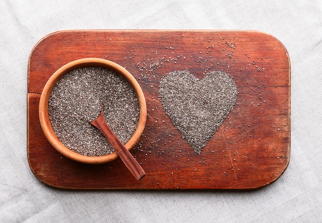 Coeur composé de graines de chia sur une table en bois. concept de santé et de saine alimentation