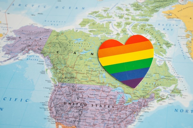 Coeur de couleur arc-en-ciel sur le symbole de fond de carte du monde globe du mois de la fierté LGBT