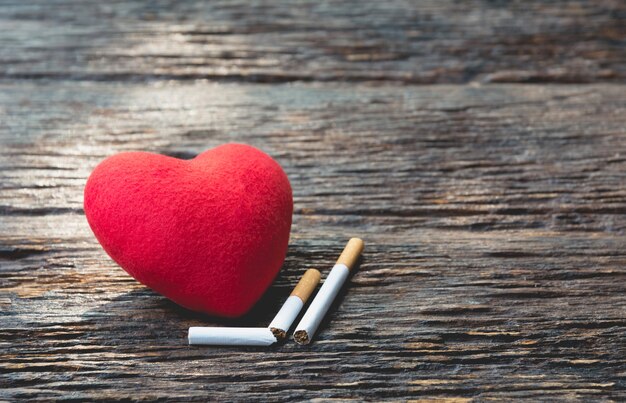 Coeur et couper la cigarette sur fond en bois. Protégez votre concept de santé.