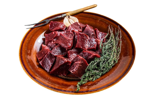 Cœur cru de bœuf ou de veau coupé dans une assiette rustique avec des herbes isolé sur fond blanc Vue supérieure