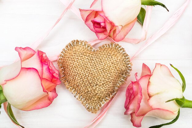 Cœur décoratif en burlap avec des roses sur fond en bois Vue supérieure Arrière-plan de vacances