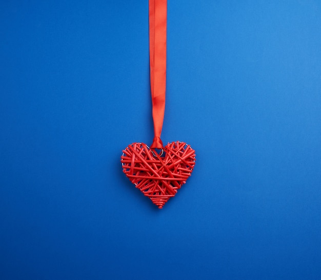 Coeur décoratif en osier rouge suspendu à un ruban de soie