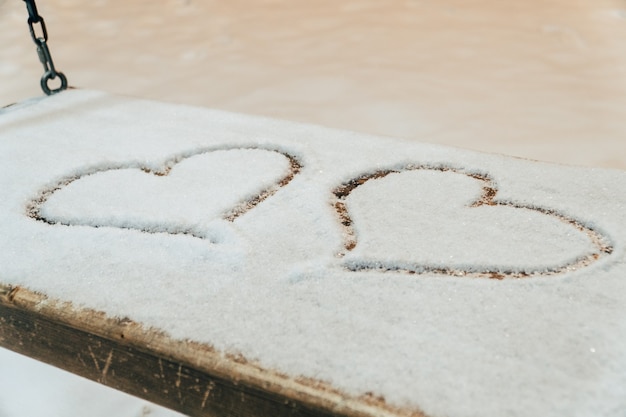 Un coeur dessiné avec un doigt sur la neige