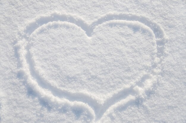 le coeur est dessiné sur la neige blanche