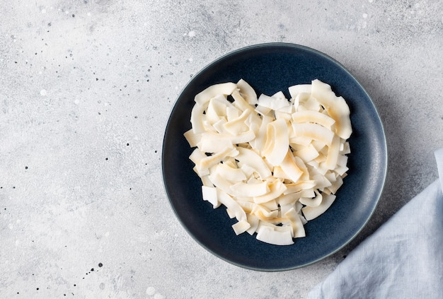 Coeur fait de copeaux de noix de coco dans une assiette bleue